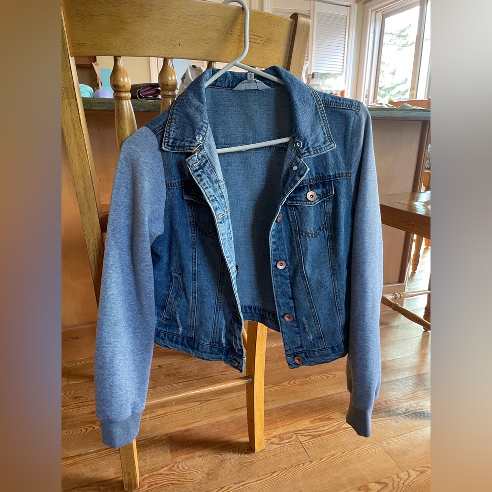 medium wash denim jacket with gray fabric sleeves with tags